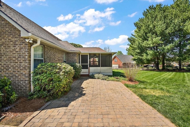 exterior space with brick siding and a yard