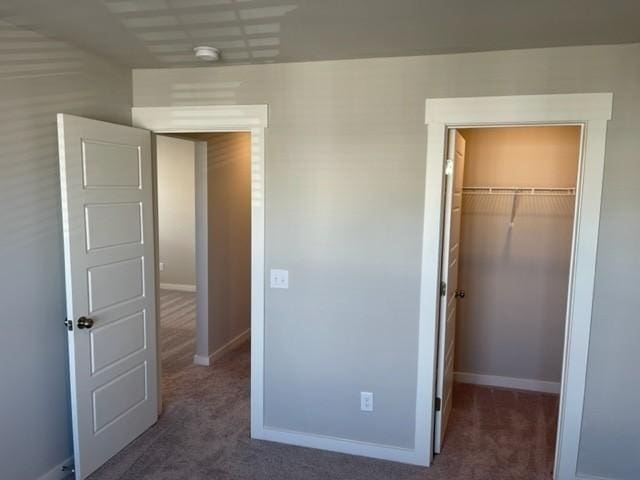 341 Casper Dr, Spring Hill, TN 37174 - unfurnished bedroom featuring a walk in closet, carpet flooring, a closet, and baseboards