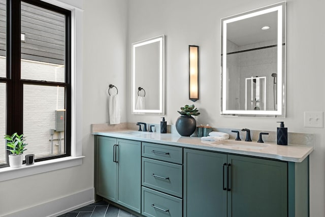 bathroom featuring double vanity, a sink, tile patterned flooring, and baseboards