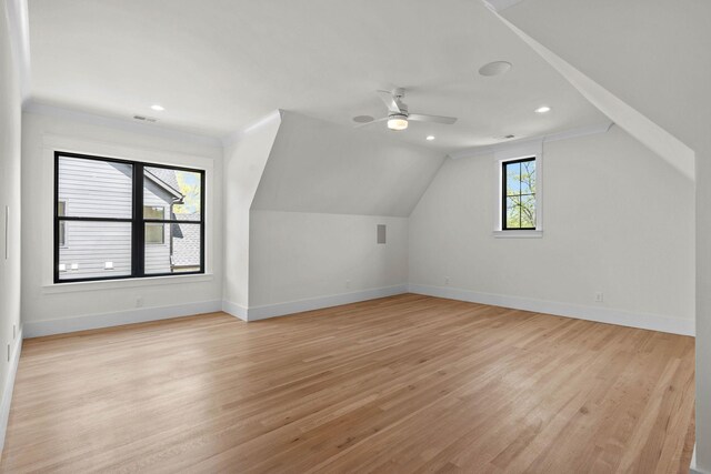 bonus room with light wood-type flooring, a ceiling fan, vaulted ceiling, and baseboards