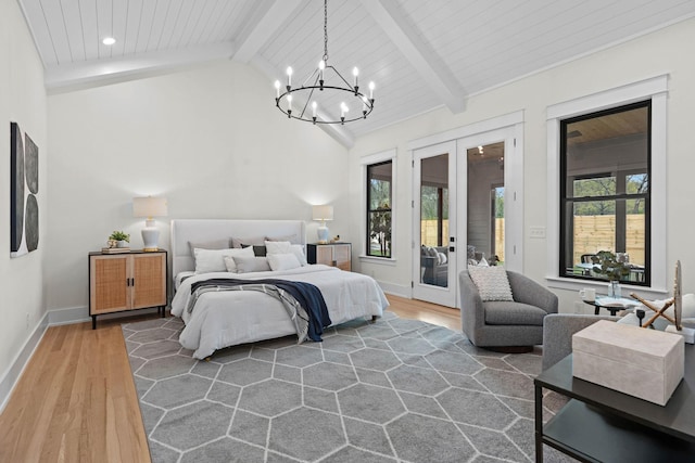 bedroom with access to outside, lofted ceiling with beams, french doors, multiple windows, and wood finished floors