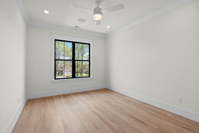 empty room featuring light wood finished floors, visible vents, baseboards, and ornamental molding