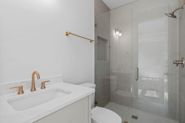 bathroom featuring toilet, a stall shower, and vanity