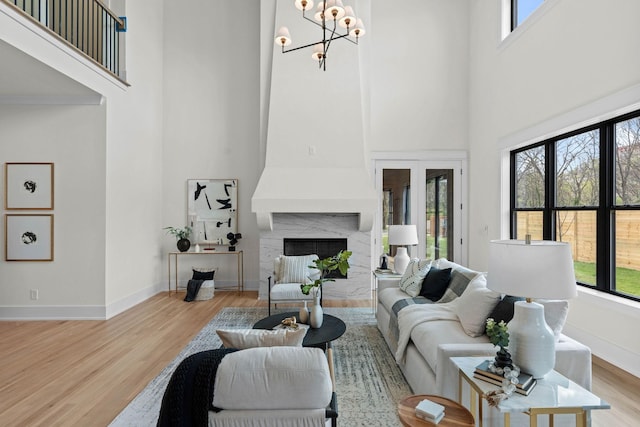 living room with light wood-style flooring, baseboards, and plenty of natural light