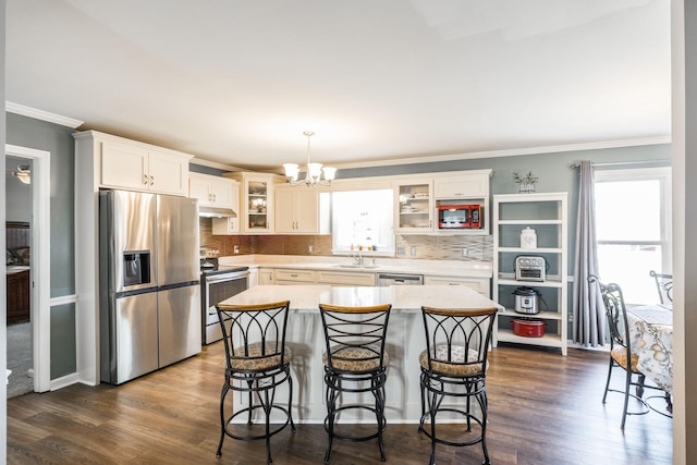 2403 English Hill Dr, Murfreesboro, TN 37130 - kitchen with dark wood-style flooring, an inviting chandelier, light countertops, under cabinet range hood, and stainless steel appliances