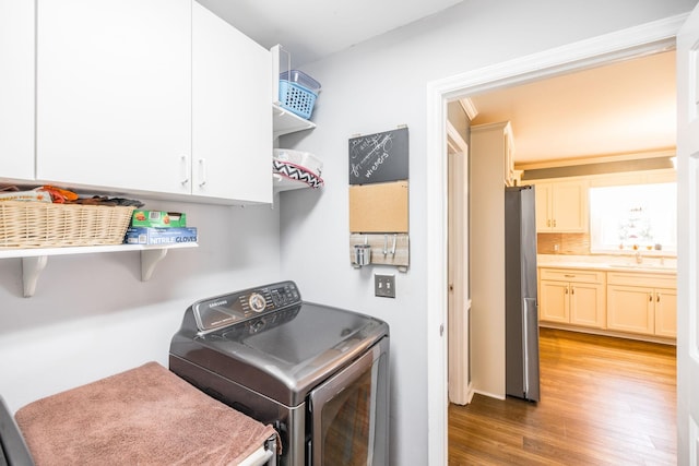 2403 English Hill Dr, Murfreesboro, TN 37130 - laundry room featuring cabinet space, washer and clothes dryer, light wood-type flooring, and a sink