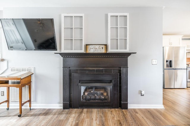 2403 English Hill Dr, Murfreesboro, TN 37130 - details with baseboards, stainless steel fridge, a fireplace, stove, and wood finished floors