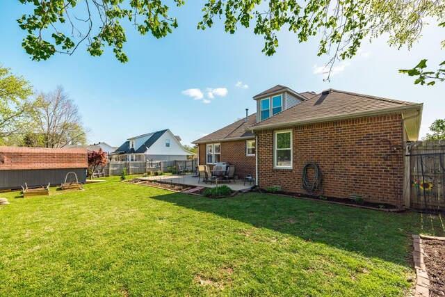 2403 English Hill Dr, Murfreesboro, TN 37130 - rear view of property with an outdoor structure, a patio area, brick siding, a fenced backyard, and a yard