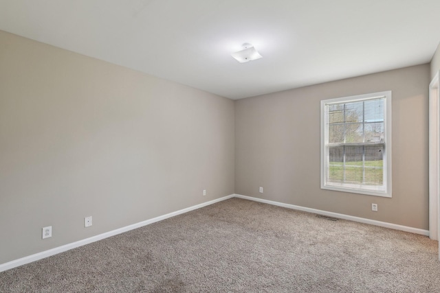 empty room featuring visible vents, baseboards, and carpet floors