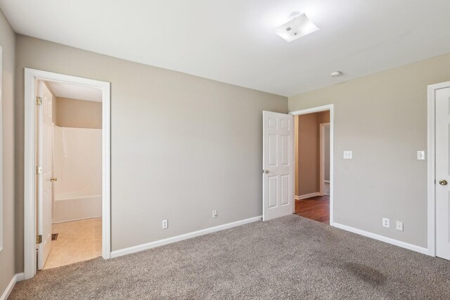 unfurnished bedroom featuring carpet flooring and baseboards