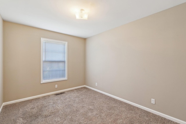 carpeted empty room featuring visible vents and baseboards