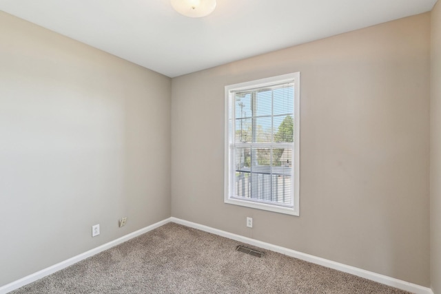 empty room featuring visible vents, baseboards, and carpet floors