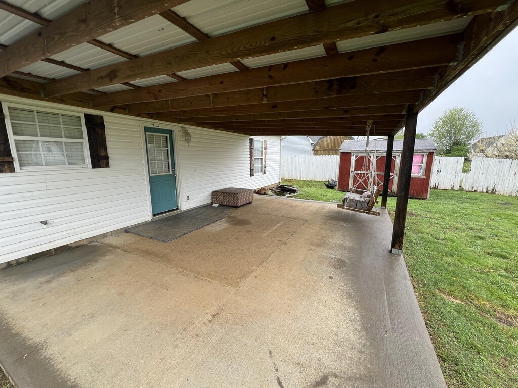 view of patio / terrace featuring a storage shed, an outbuilding, and fence private yard