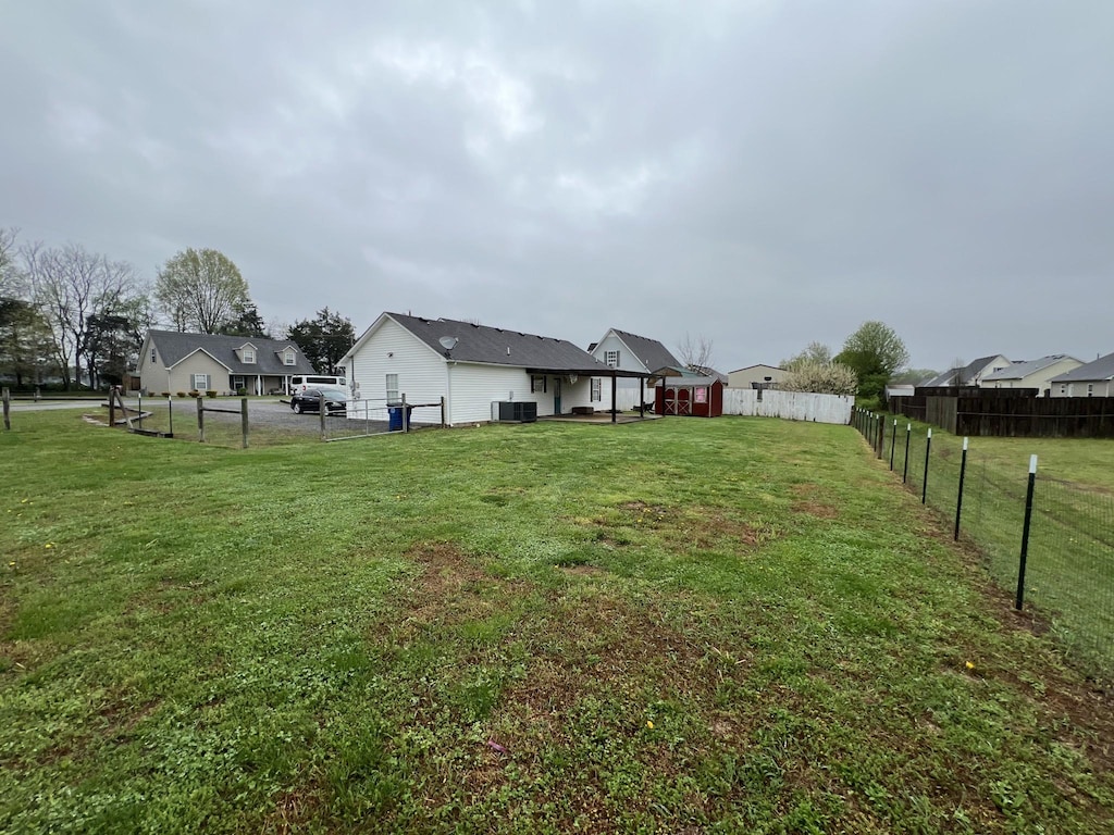 view of yard with cooling unit and fence