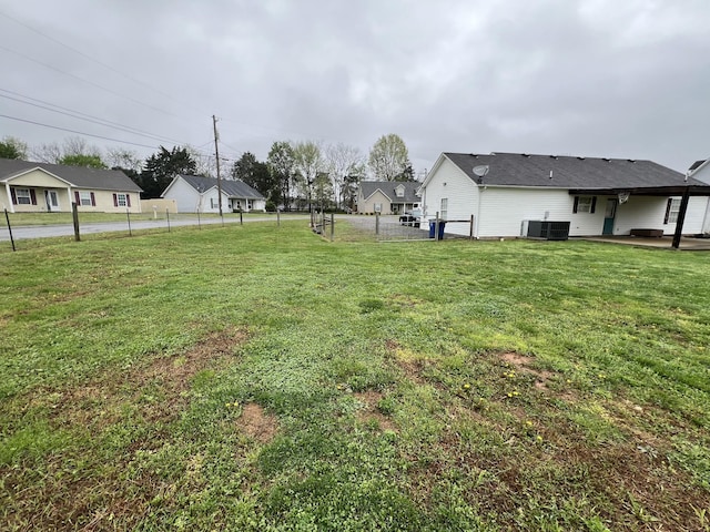 view of yard with central AC and fence