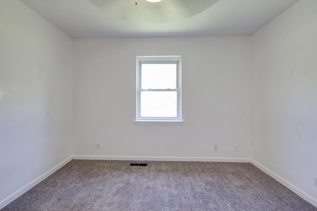 carpeted spare room with baseboards and visible vents