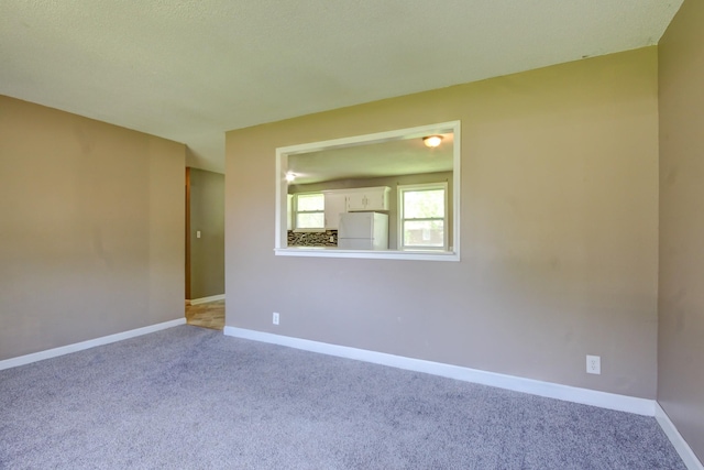 carpeted spare room featuring baseboards