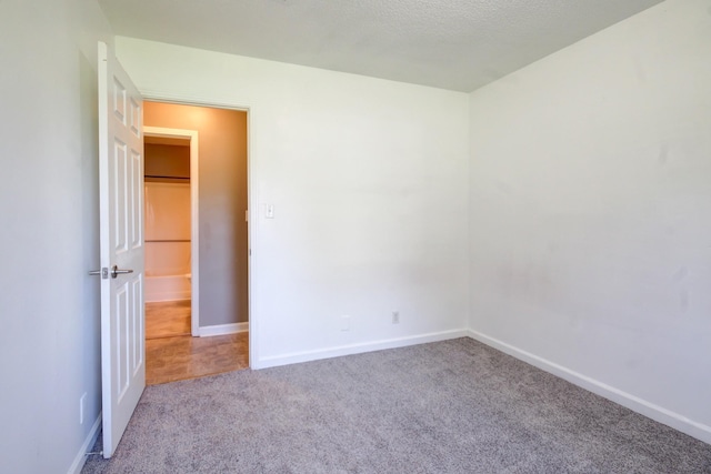 carpeted empty room featuring baseboards
