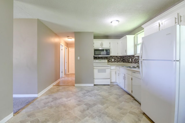 kitchen with a textured ceiling, a sink, backsplash, white cabinetry, and white appliances