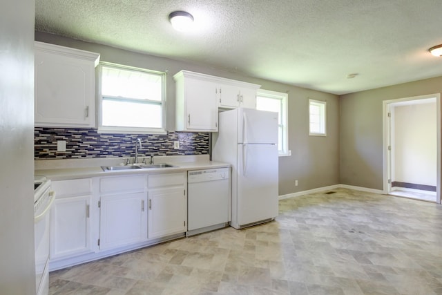 kitchen with a sink, decorative backsplash, white appliances, light countertops, and white cabinets