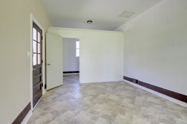 spare room with stone finish floor and baseboards
