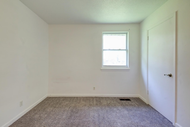 carpeted empty room with baseboards and visible vents