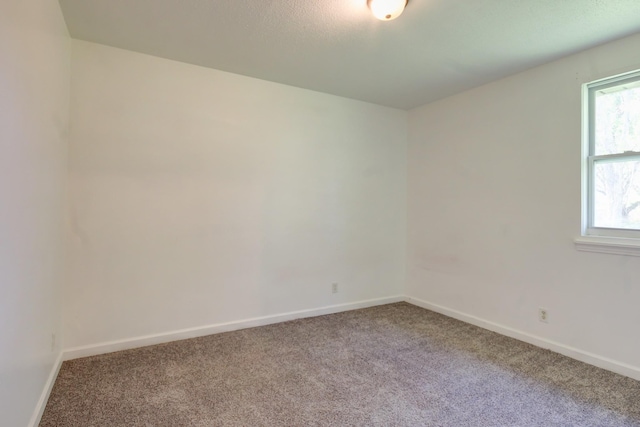 carpeted spare room with baseboards