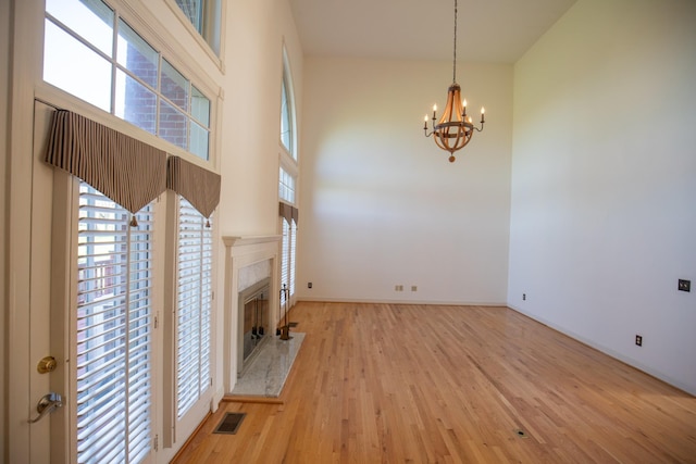 2132 Neelys Bend Rd, Madison, TN 37115 - unfurnished living room featuring a chandelier, wood finished floors, a fireplace, baseboards, and a towering ceiling
