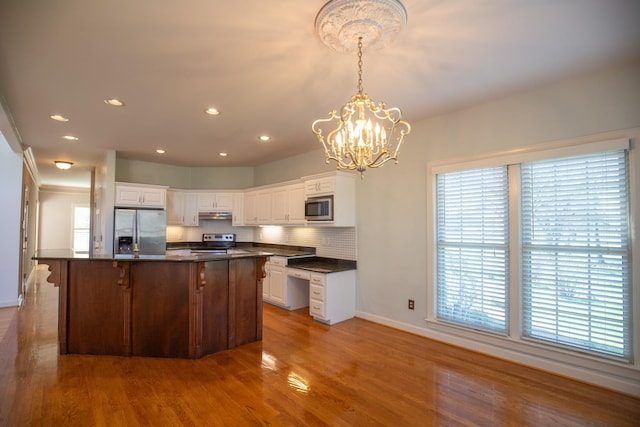 2132 Neelys Bend Rd, Madison, TN 37115 - kitchen featuring stainless steel appliances, dark countertops, under cabinet range hood, baseboards, and white cabinets