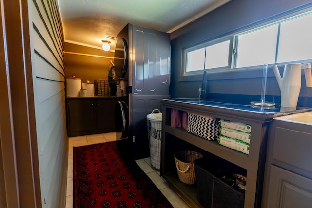 501 Burnt Hill Rd, Unionville, TN 37180 - clothes washing area featuring light tile patterned floors, cabinet space, and stacked washer / drying machine