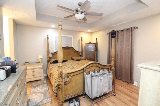 320 Benson Rd, Reagan, TN 38368 - bedroom with baseboards, a raised ceiling, light wood-style flooring, a textured ceiling, and ceiling fan