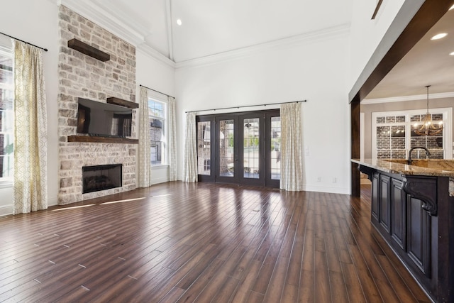 61 Harbor Cove Dr, Old Hickory, TN 37138 - unfurnished living room with dark wood-style flooring, a stone fireplace, baseboards, french doors, and a high ceiling