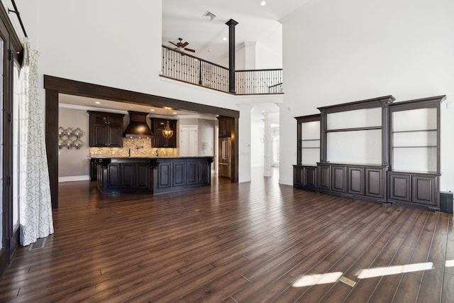 61 Harbor Cove Dr, Old Hickory, TN 37138 - unfurnished living room with a towering ceiling, dark wood-style flooring, ornate columns, and ceiling fan