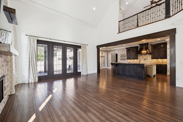 61 Harbor Cove Dr, Old Hickory, TN 37138 - unfurnished living room with a stone fireplace, baseboards, dark wood-style floors, high vaulted ceiling, and ceiling fan with notable chandelier