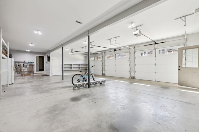 61 Harbor Cove Dr, Old Hickory, TN 37138 - garage featuring visible vents, freestanding refrigerator, and a garage door opener
