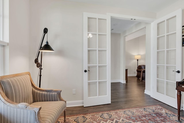 sitting room with french doors, baseboards, and wood finished floors