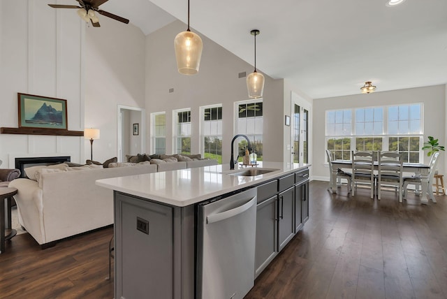 kitchen featuring a sink, open floor plan, dark wood-style flooring, a ceiling fan, and stainless steel dishwasher
