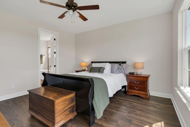 bedroom featuring dark wood-style floors, baseboards, a ceiling fan, and ensuite bathroom