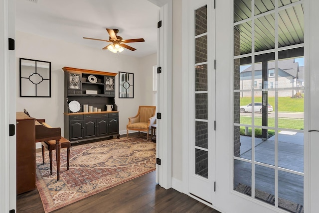 doorway to outside with dark wood-type flooring, ceiling fan, and baseboards