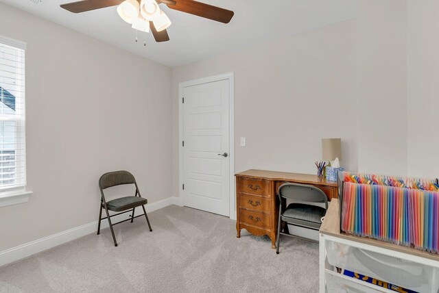 carpeted home office featuring ceiling fan, baseboards, and plenty of natural light