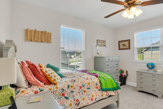 bedroom featuring baseboards, a ceiling fan, and light colored carpet
