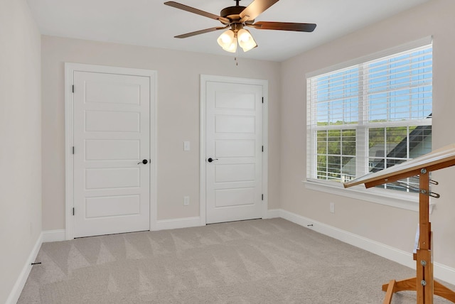 unfurnished bedroom featuring carpet floors, baseboards, and ceiling fan