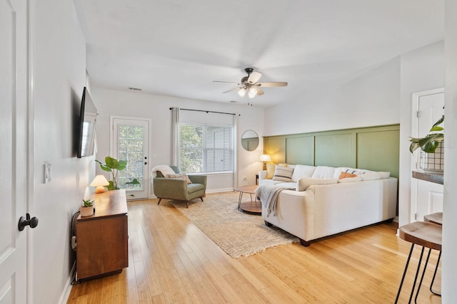 living area featuring light wood-style floors, ceiling fan, and visible vents