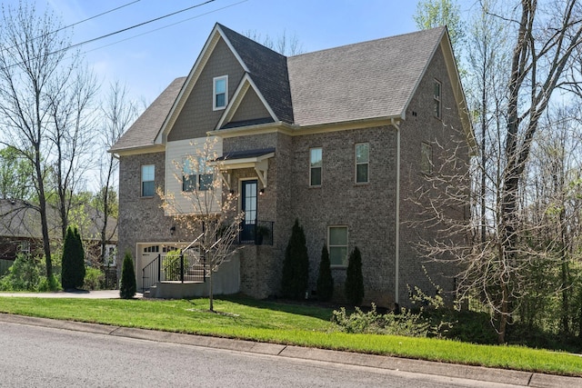 view of front of home with roof with shingles, brick siding, driveway, and a front lawn