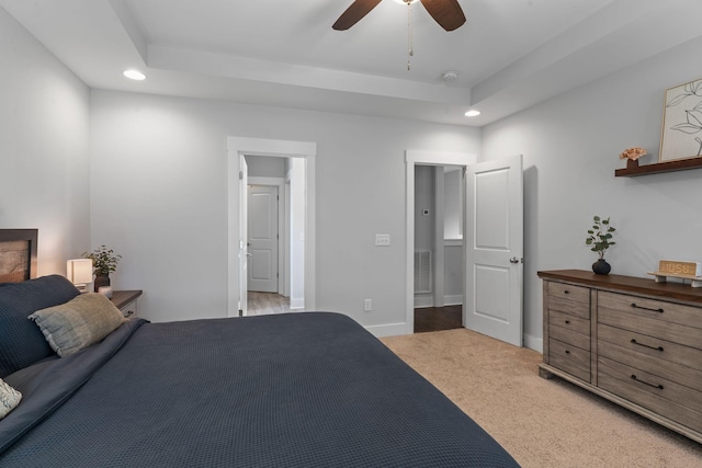 bedroom with baseboards, recessed lighting, a tray ceiling, ceiling fan, and light colored carpet