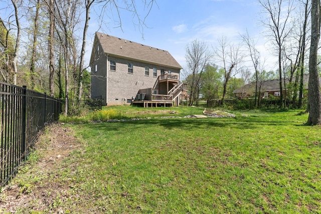 rear view of house featuring a deck, a lawn, a fenced backyard, stucco siding, and stairs