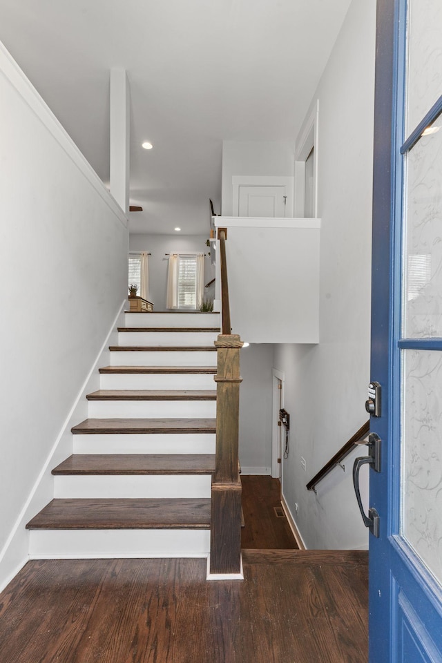 stairway featuring wood finished floors and recessed lighting