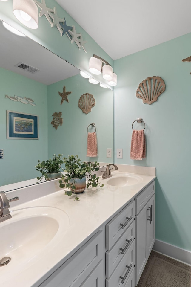 full bath featuring a sink, visible vents, baseboards, and double vanity