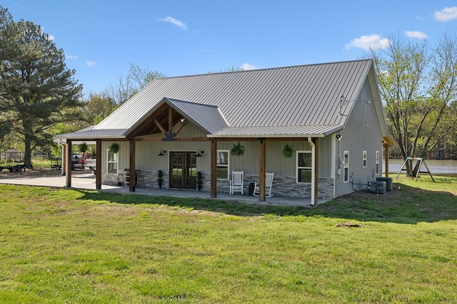 208 Lakeview Dr, Hohenwald, TN 38462 - rear view of house with a lawn, stone siding, a patio, and metal roof