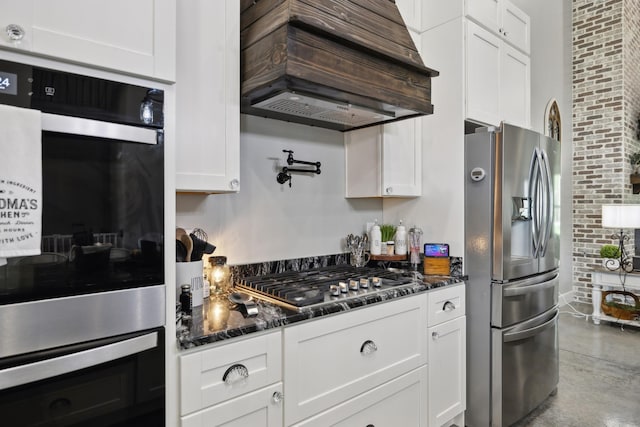 208 Lakeview Dr, Hohenwald, TN 38462 - kitchen featuring stainless steel appliances, custom exhaust hood, white cabinetry, dark stone countertops, and finished concrete flooring